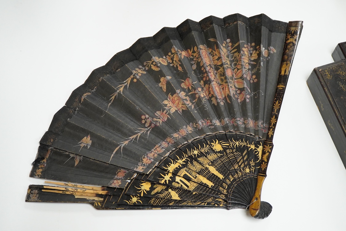 Four 19th century Chinese gilt-decorated black lacquer fans with figure painted leaves, two cased, largest 41cm